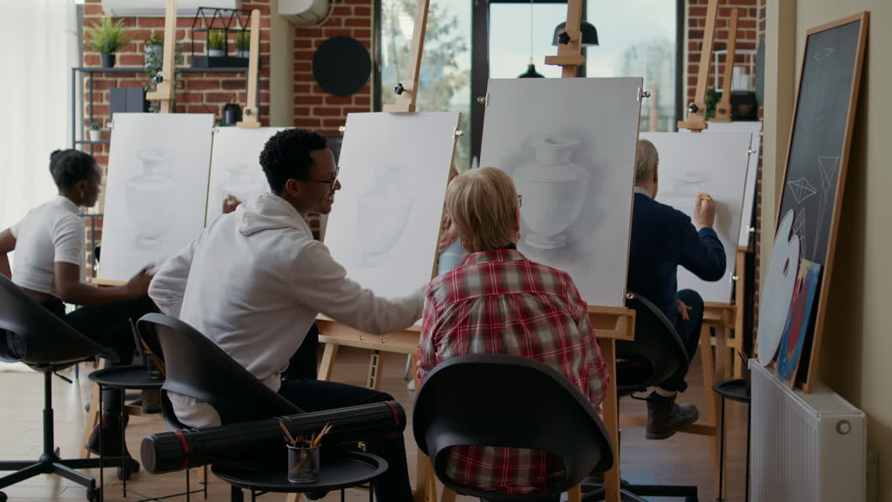 Young man helping elder woman with drawing technique
