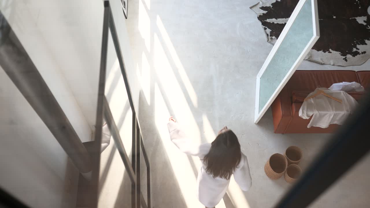 mujer con una túnica blanca en un apartamento moderno