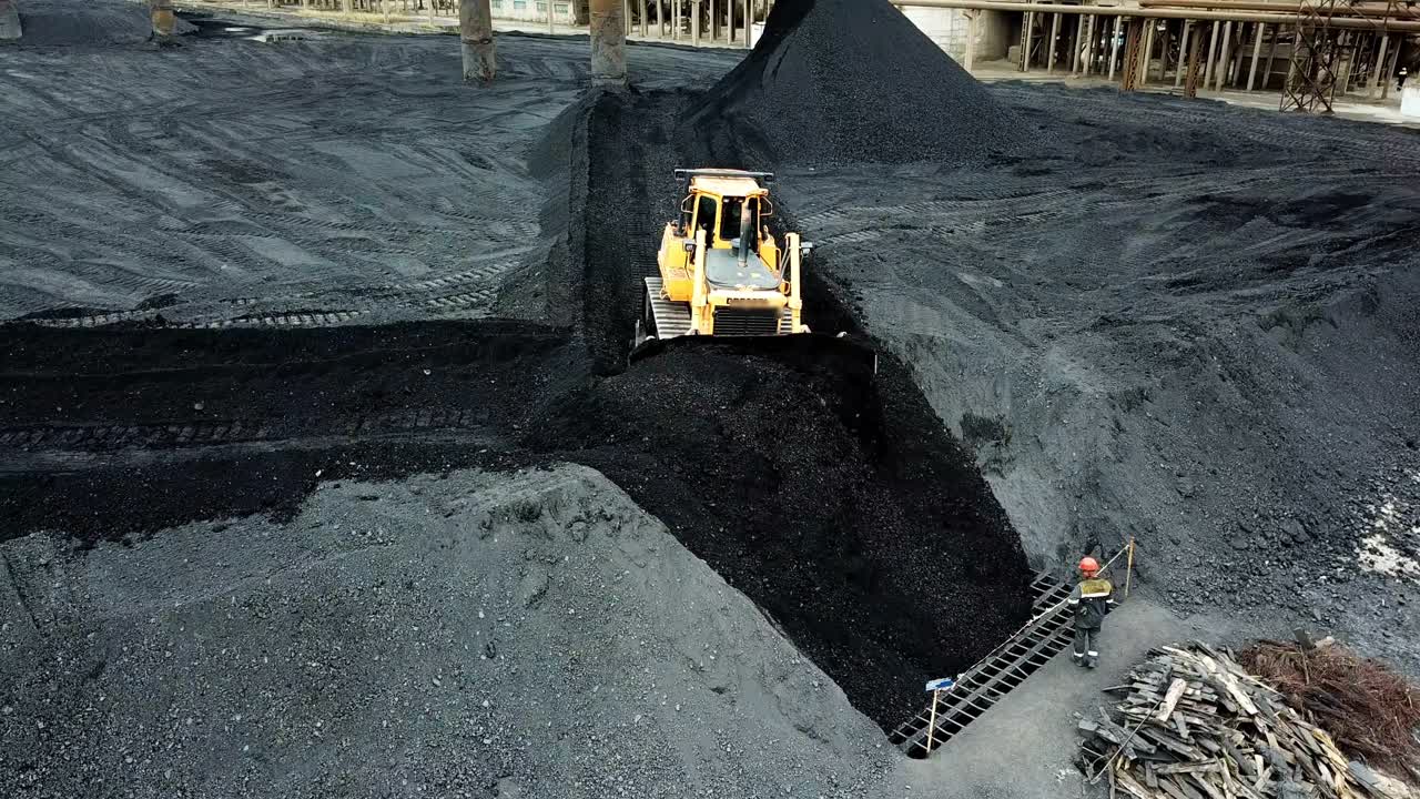 Moving tractor coal around plant for processing. Coal Production. Aerial view.