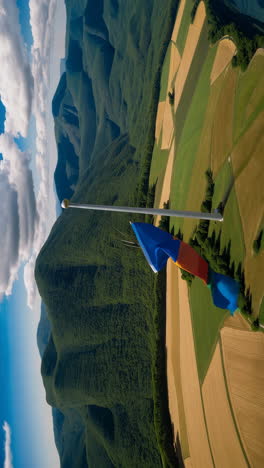 aerial view of mountains and fields with flag