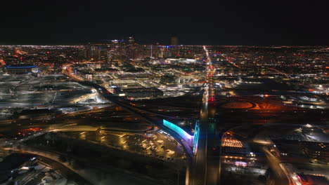 denver downtown i25 highway traffic aerial drone cinematic anamorphic snowy winter evening dark night city lights landscape colorado mile high du metro state ball arena forward pan reveal motion