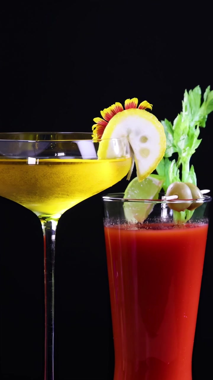 Farverige cocktails med pynt vises på en sort baggrund, der fremhæver deres levende farver og elegante præsentation.