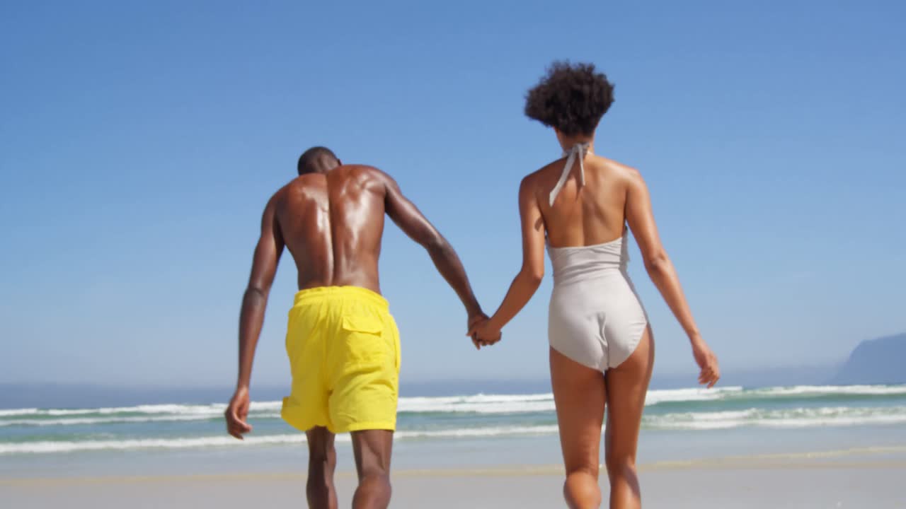 Romantic couple running hand in hand at beach 4k