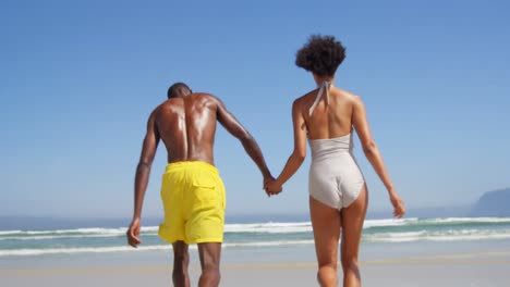 Romantic-couple-running-hand-in-hand-at-beach-4k