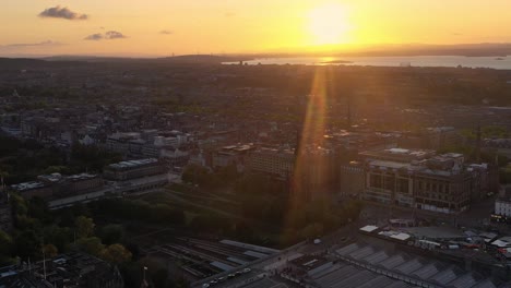 Malerisches-Stadtbild-Von-Edinburgh-Am-Bahnhof-Waverley-Bei-Sonnenuntergang,-Drohnenaufnahme-Aus-Der-Luft,-Schottland,-Kreisschwenk