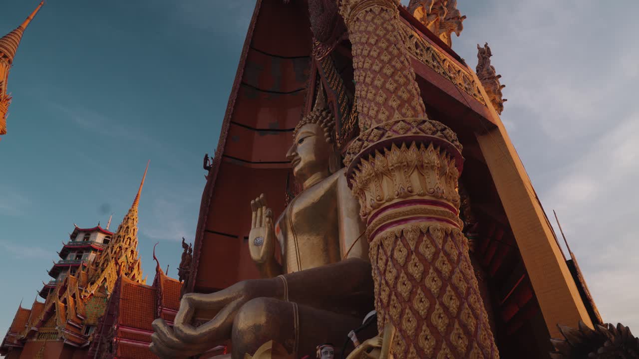 Maestosa statua dorata di Buddha in un tempio tradizionale thailandese