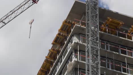 Tilt down shot of a high building under works with a crane