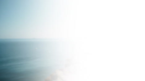 ocean waves crashing on beach, animation of bright sunlight reflecting on water
