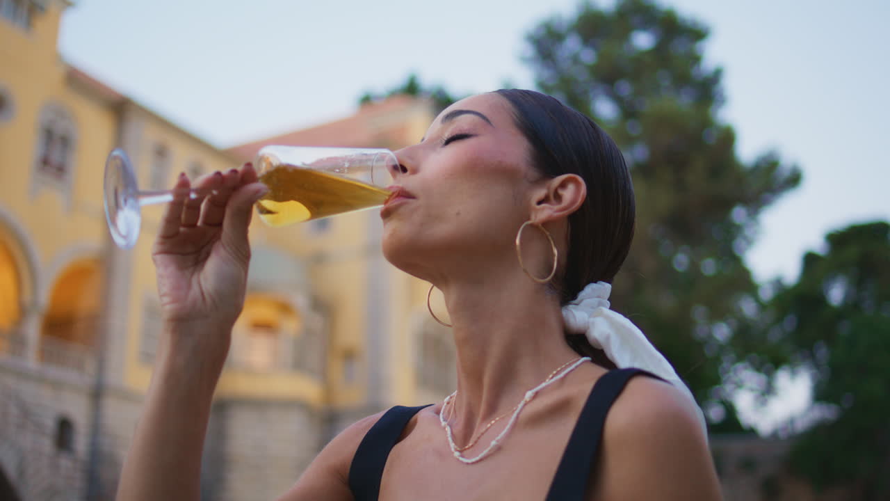 mujer disfrutando del vino frente a un castillo