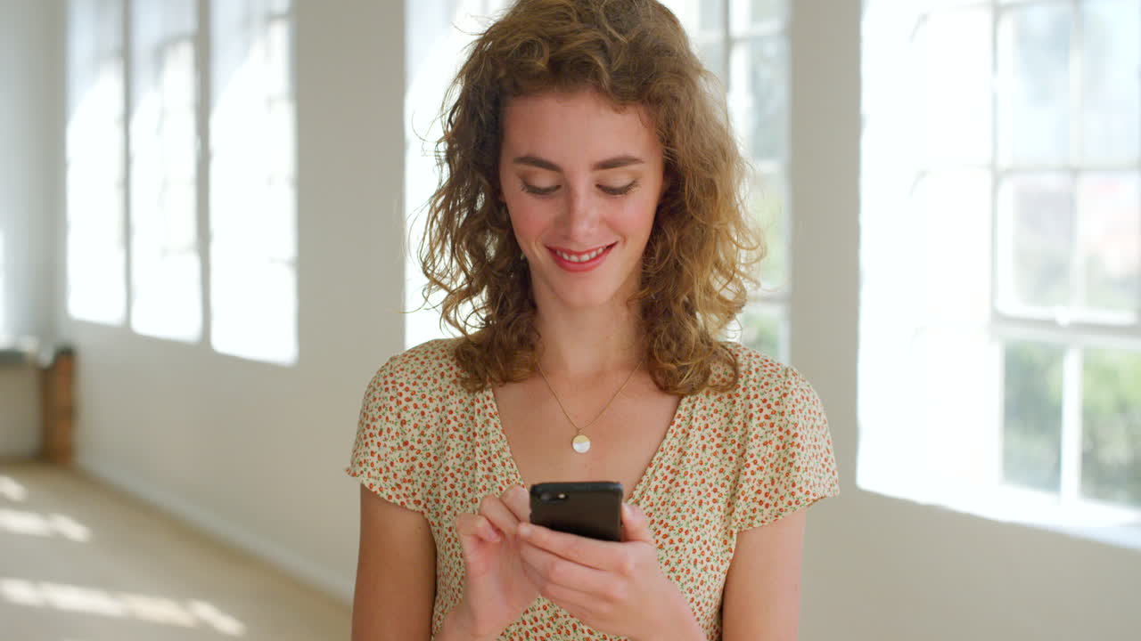 Giovane donna felice che invia messaggi al telefono a casa