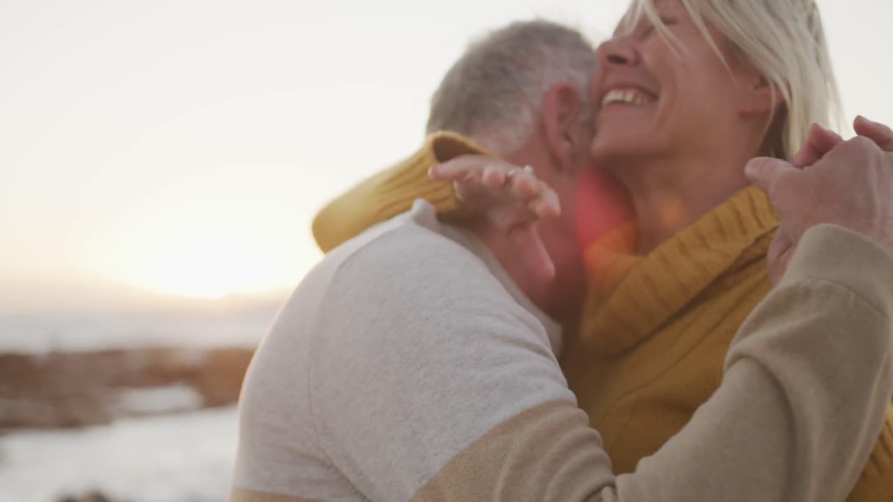 una pareja feliz bailando en la playa.