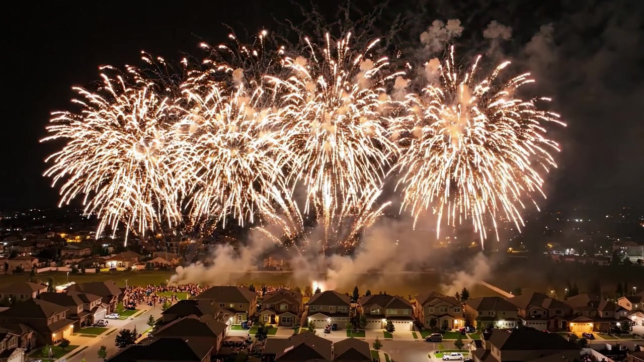 Spettacolare spettacolo pirotecnico notturno su una comunità suburbana, che illumina il cielo con colori vivaci e crea un'atmosfera di festa memorabile.