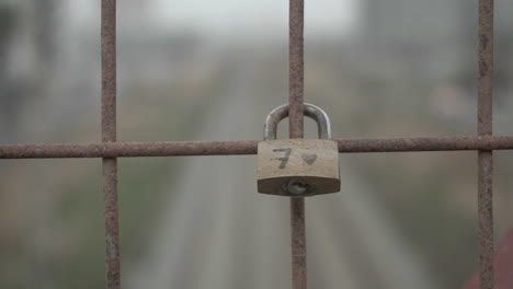 slide to the right shot of a lonely love lock with the number seven on it