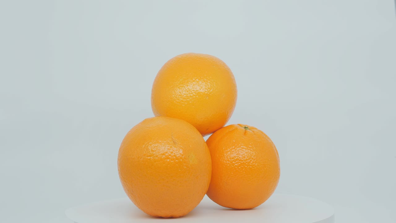 sobre un fondo blanco. la pirámide de cítricos naranja gira sobre su eje.
