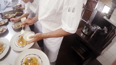 Mid-section-of-chefs-garnishing-food