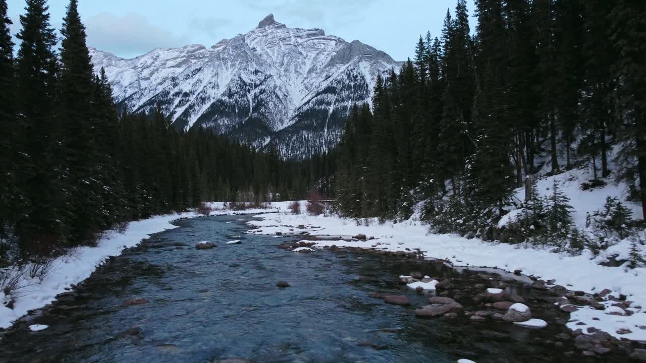 arroyo en el bosque de montaña puente río abajo revelar invierno