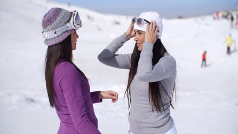 Two-stylish-young-woman-chatting-at-a-ski-resort