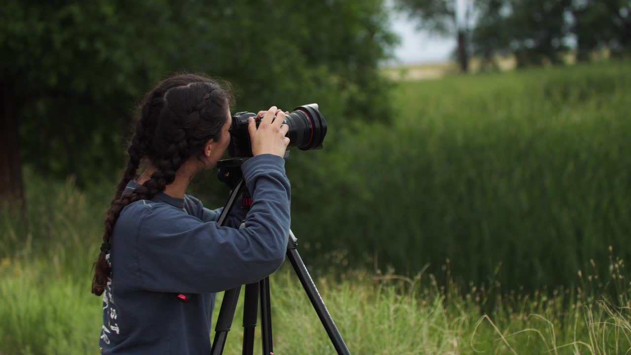 fotógrafo femenino en la naturaleza se vuelve y sonríe a la cámara