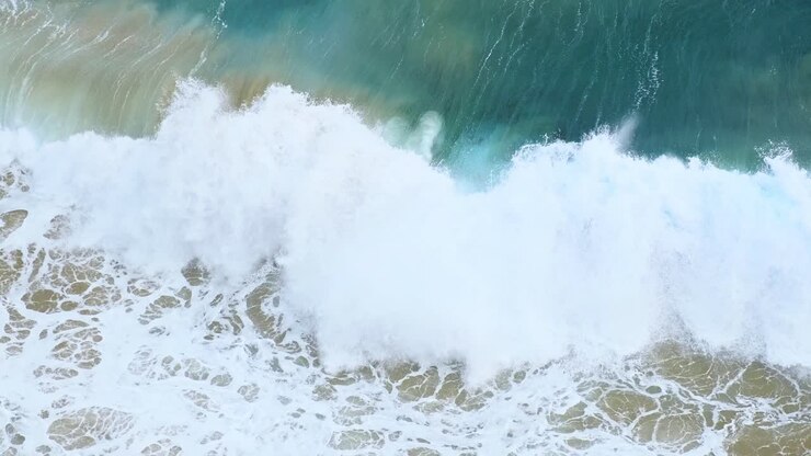 Swell of blue and emerald color Cantabrian sea hitting the beach of Isla island