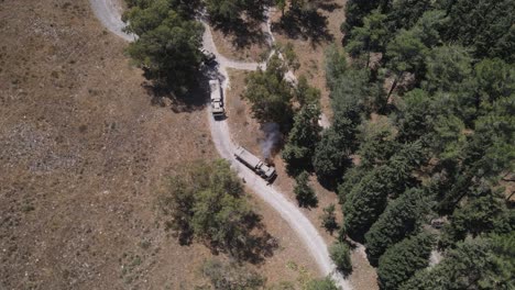 vehículos del ejército de israel de pie en fila en un estrecho camino de campo, disparo aéreo