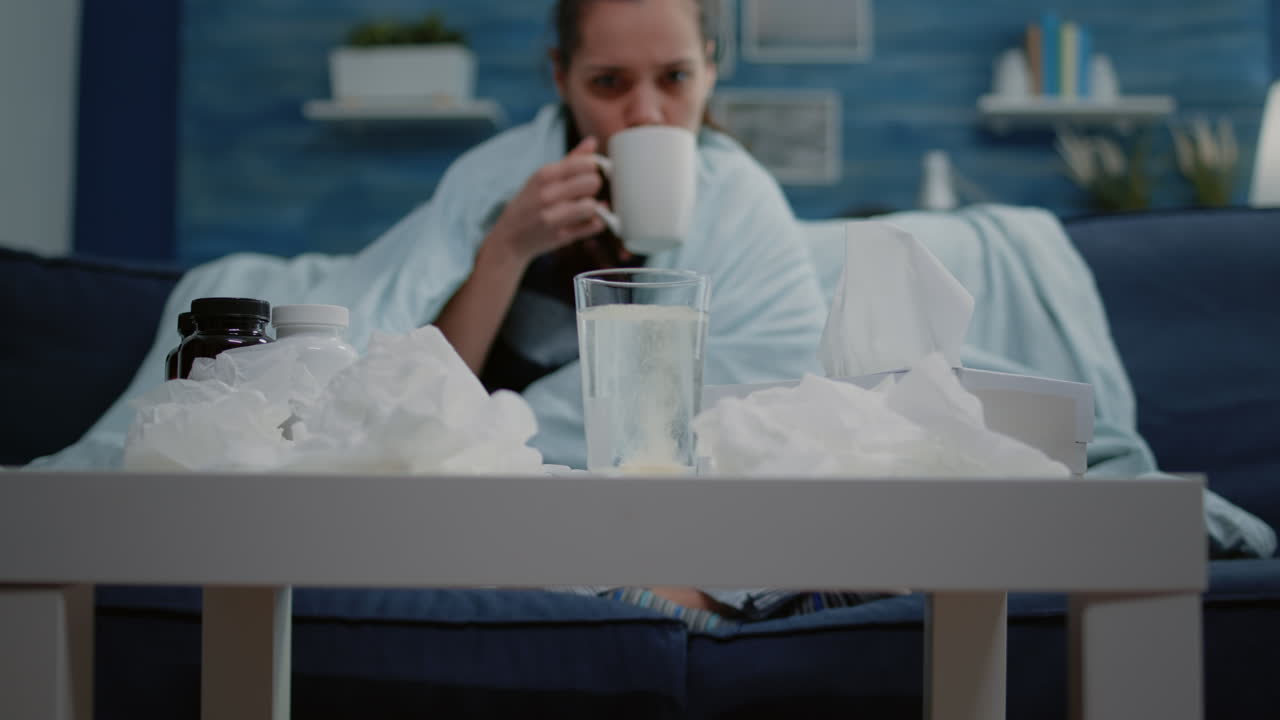 Close up of woman putting effervescent pill in glass of water