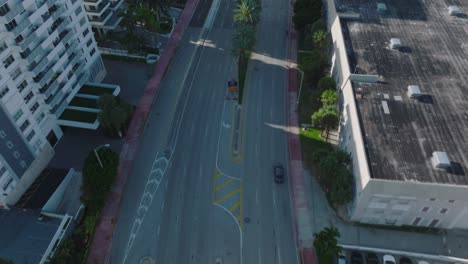 birds eye view of wide multilane road in town, tilt up reveal high rise apartment buildings in luxurious residential borough. miami, usa