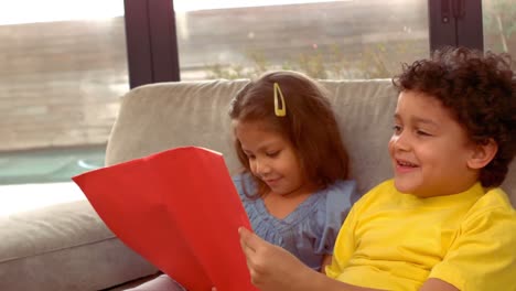 niños hispanos leyendo juntos un libro