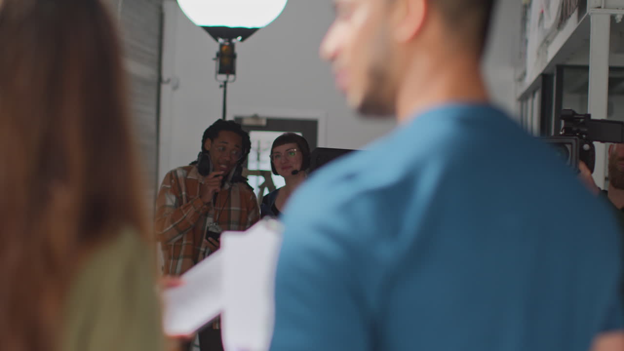 actores que trabajan en el set rodando una película o un video en el estudio con una directora, un camarógrafo, un grabador de sonido y un asistente 2