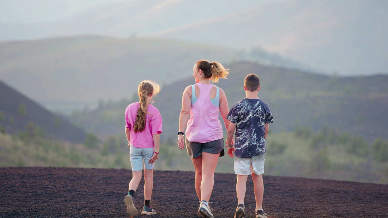 Family walks on a scenic volcanic landscape