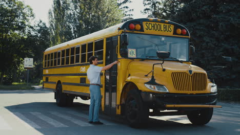 Man-driver-coming-up-schoolbus-press-button-alone.-Operator-enter-yellow-bus.