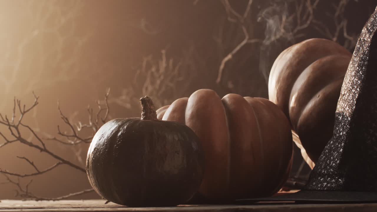 video de calabazas de halloween, sombrero, humo y espacio de copia sobre fondo marrón