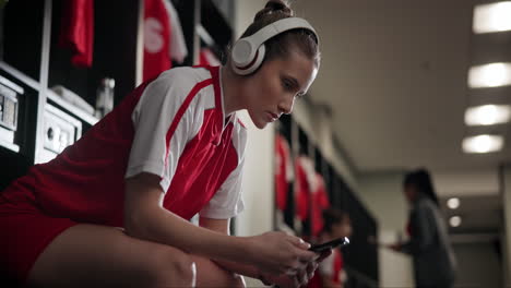 female athlete using cellphone in locker room