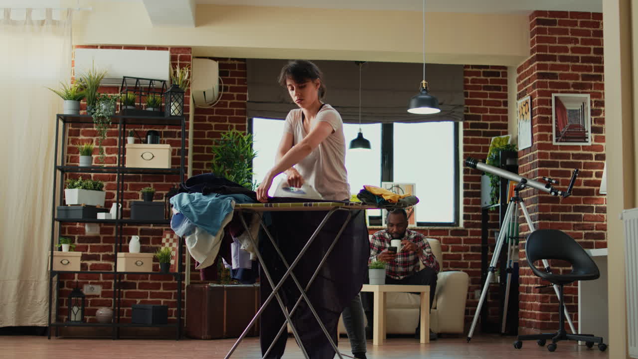 Aggressive woman ironing shirt and getting frustrated at boyfriend