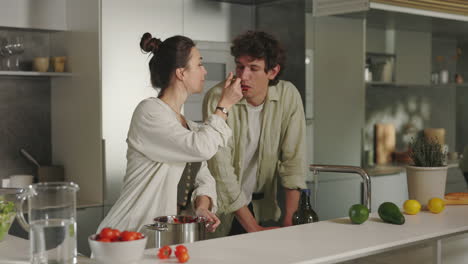 couple cooking and tasting food in a modern kitchen