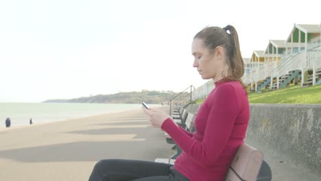 Junge-Frau-Schaltet-Ihr-Telefon-Aus-Und-Entspannt-Sich-Am-Strand