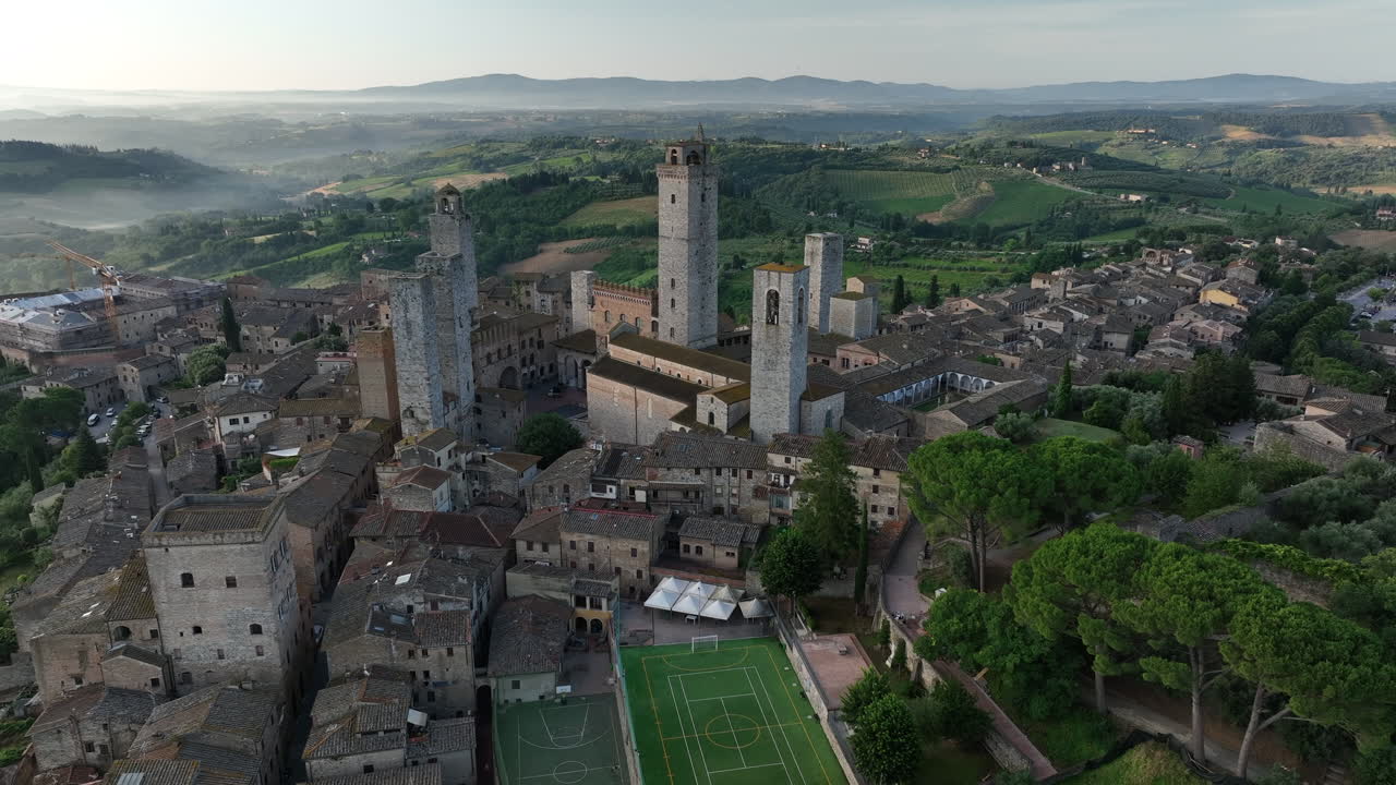 Early morning in San Gimignano in Tuscany overlooking the town and surrounding landscapes surrounded by fog, Italy