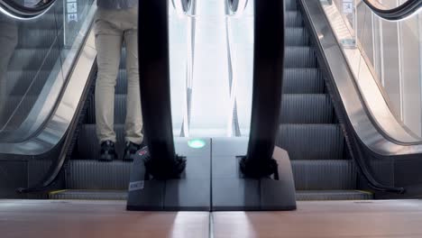 young man walking up on modern escalator stairs. moving staircase running up and down. urban lifestyle concept.