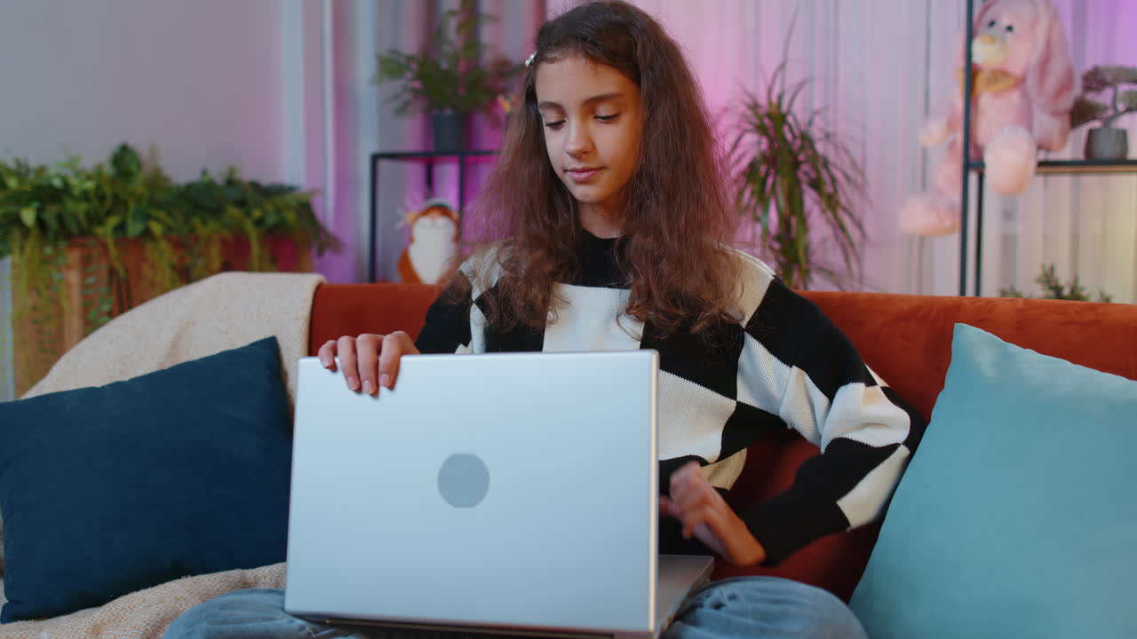 joven freelancer acostada en el sofá cerrando la computadora portátil después de terminar el trabajo en la sala de estar en casa