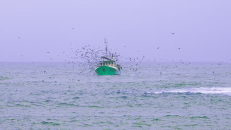 un barco de pesca rodeado de gaviotas en una tarde tormentosa
