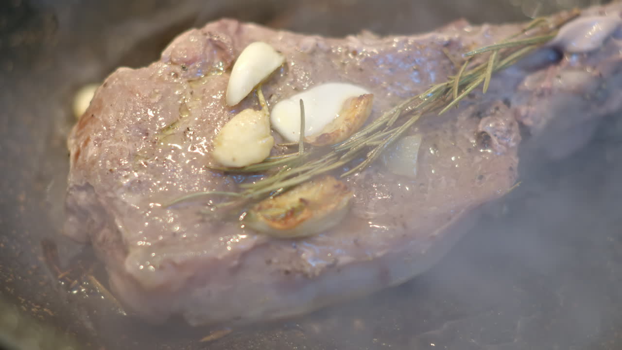 Juicy ribeye steak meat beef being prepared with rosemary and garlic