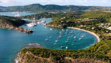 Toma-Aérea-Soleada-Del-Puerto-Inglés-En-Antigua,-Caribe-Con-Vistas-De-Yates,-Veleros,-Puerto-Deportivo,-Bahía-Y-Acantilados