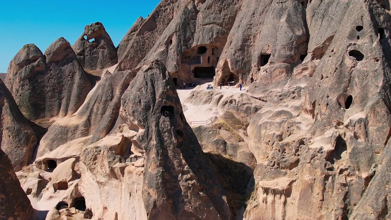 Vedute della Cappadocia con formazioni rocciose e case sotto un cielo sereno