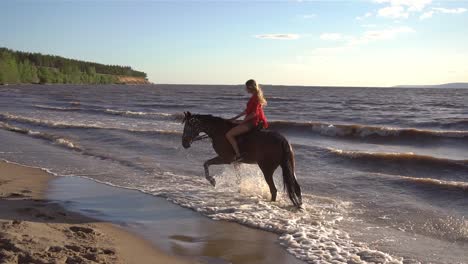 mujer montando a caballo en la playa al atardecer