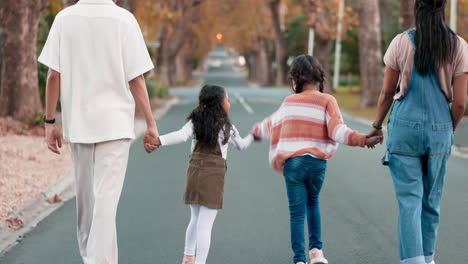 back, family and holding hands in the street