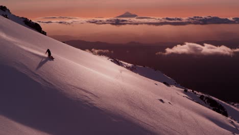 Epische-Szene-Von-Zwei-Freeride-Snowboardern,-Die-In-Der-Abenddämmerung-Einen-Verschneiten-Hang-Hinunterfahren