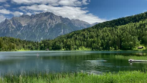 lauter lake in summer with stand up paddle and karwendel mountains in the background, very close to the bavarian town of mittenwald in germany