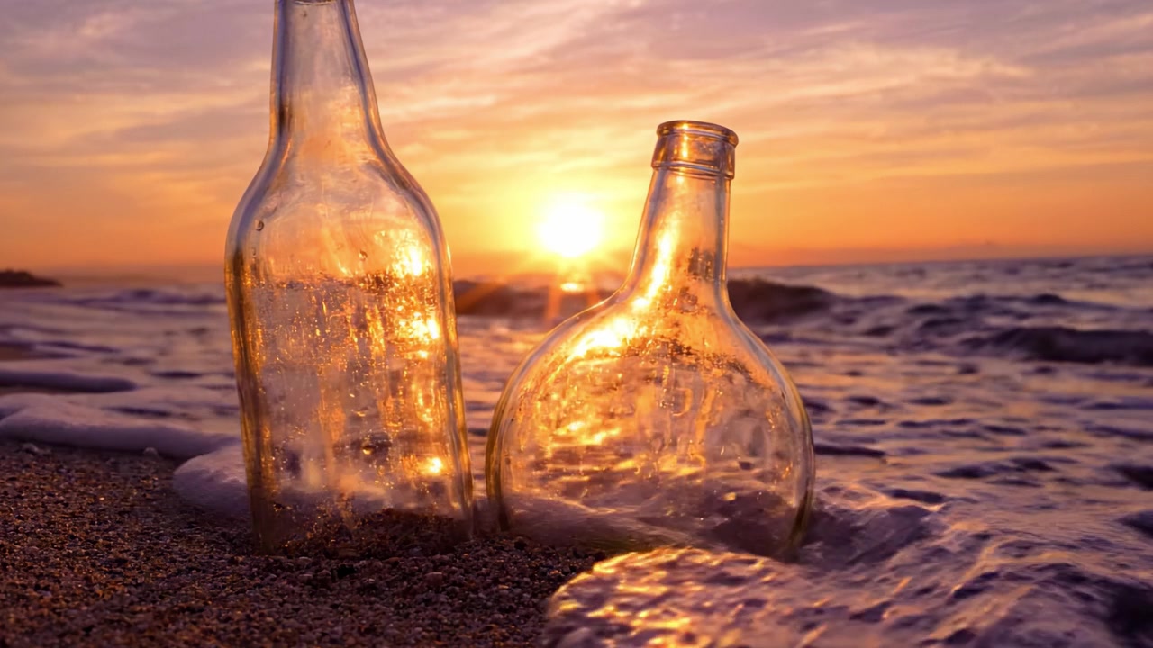 Un bellissimo tramonto illumina due bottiglie di vetro su una spiaggia sabbiosa, creando una scena serena dove natura e oggetti artificiali coesistono armoniosamente durante le ore del crepuscolo.