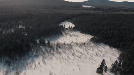 Luftaufnahmen-Von-Drohnenaufnahmen-Eines-Sonnigen-Tages-Mit-Wolken-über-Einer-Winterlandschaft,-Einschließlich-Wald-Und-Bäumen,-Bergen-Und-Offenen-Feldern-In-Quebec,-Kanada-Während-Des-Kanadischen-Winters