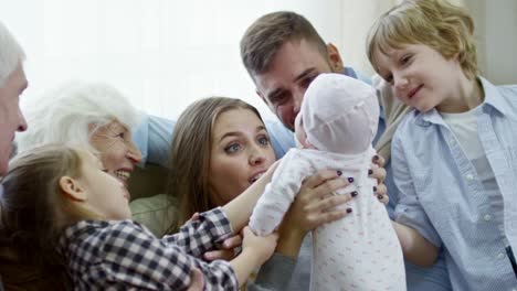 big family playing with cute baby