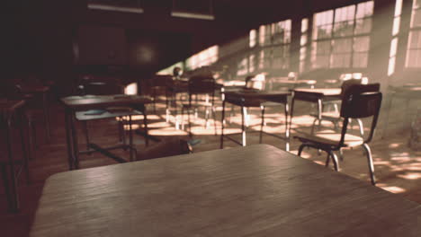 view to classroom with tables and small blackboard and grungy walls